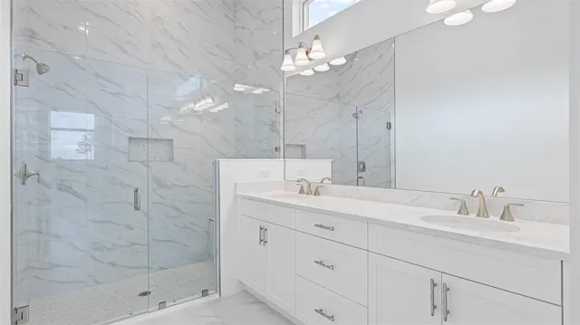 a bathroom with a double vanity sink mirror and shower