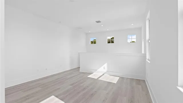 a view of empty room with wooden floor