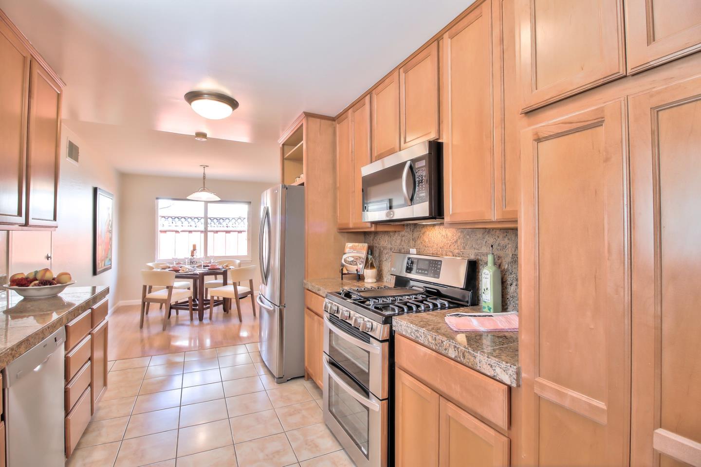 2221 Sutter Avenue Santa Clara, CA 95050 - Photo 12 of 29 a kitchen with stainless steel appliances granite countertop a stove top oven a sink a dining table and chairs