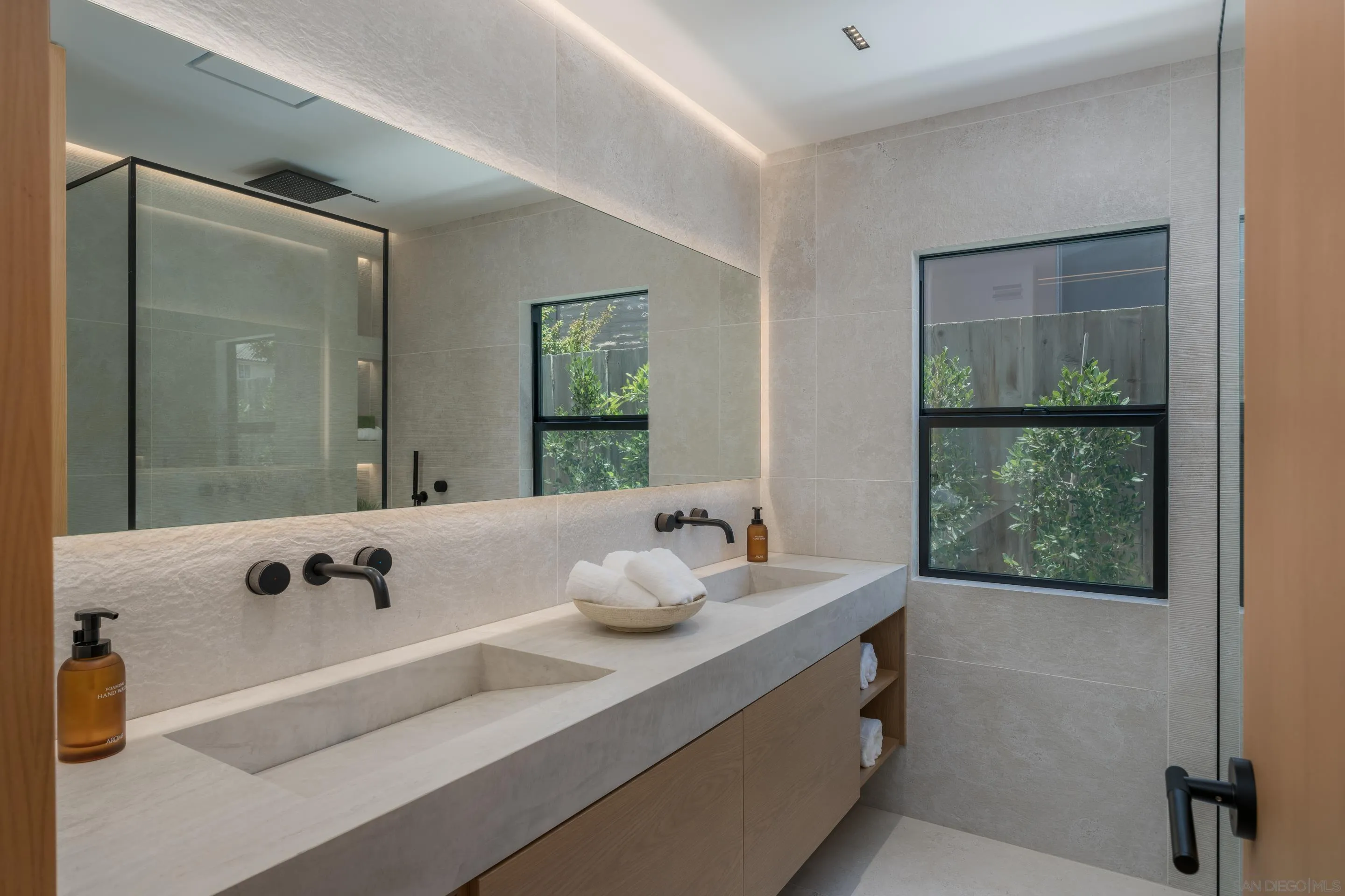 5826 Soledad Mountain Road La Jolla, CA 92037 - Photo 23 of 52 a bathroom with a tub sink and mirror