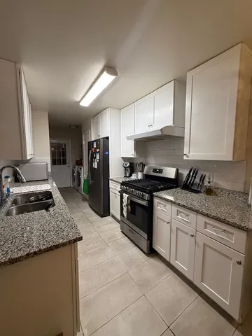 a kitchen with stainless steel appliances granite countertop a sink stove and refrigerator