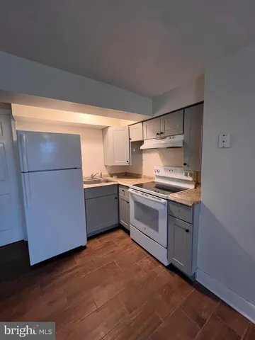 a kitchen with granite countertop a refrigerator and a stove top oven