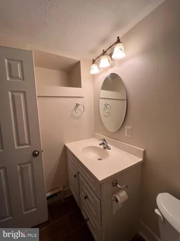 a bathroom with a sink mirror vanity and toilet