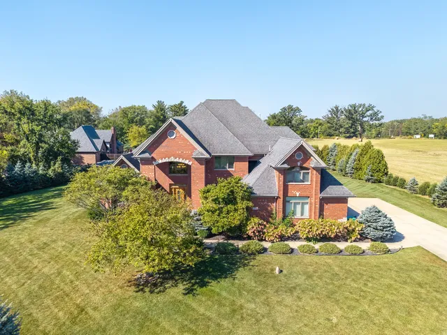 an aerial view of house with yard and mountain view in back
