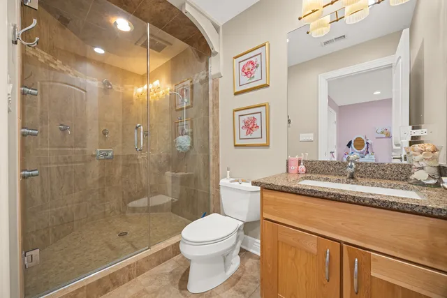 a bathroom with a granite countertop sink a toilet and shower
