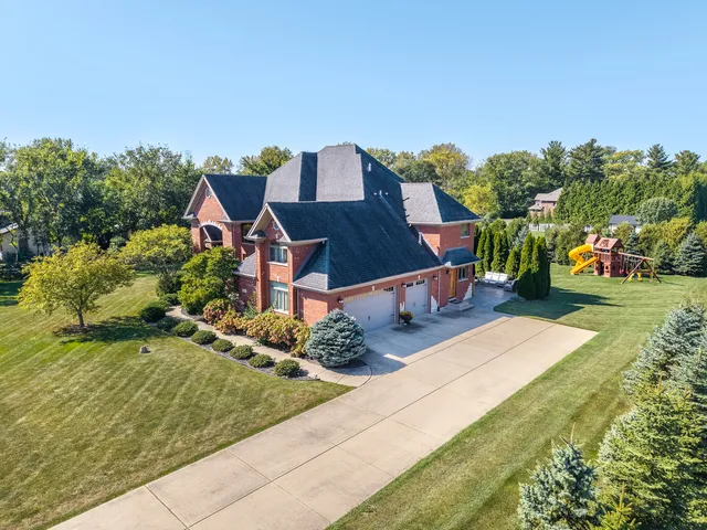 an aerial view of a house with a yard basket ball court and outdoor seating