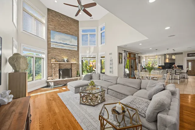 a living room with furniture a large window and wooden floor