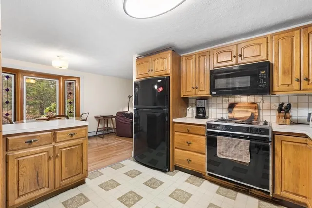 a kitchen with stainless steel appliances granite countertop a stove top oven a sink dishwasher and cabinets with wooden floor