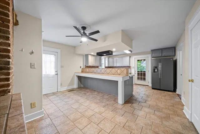 a large white kitchen with a sink and dishwasher a refrigerator with wooden floor