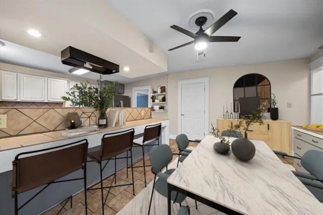 a kitchen with a table chairs a stove a chimney a dining table and chairs