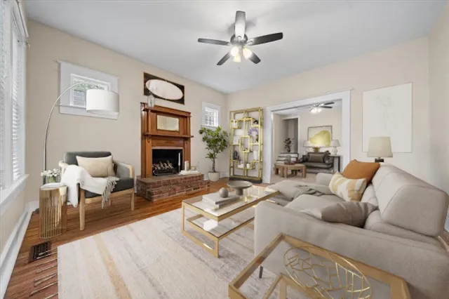 a living room with furniture a fireplace and a ceiling fan