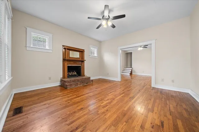a view of empty room with wooden floor and fireplace