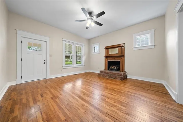a view of empty room with wooden floor and fireplace