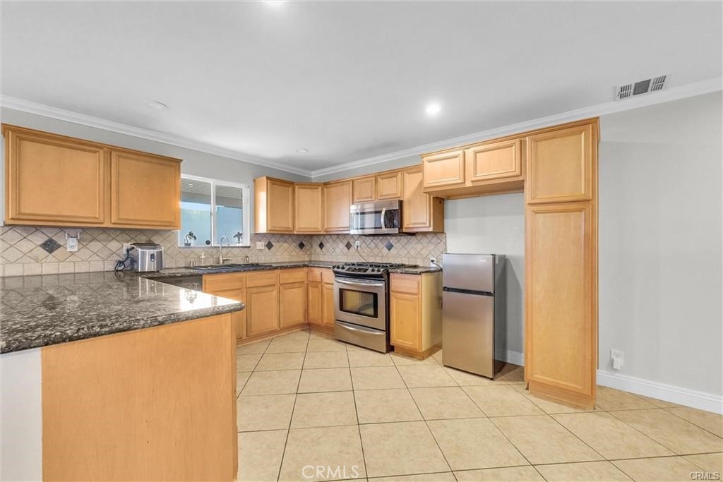 6220 Filkins Avenue Rancho Cucamonga, CA 91737 - Photo 6 of 16 a kitchen with stainless steel appliances granite countertop a sink stove and refrigerator