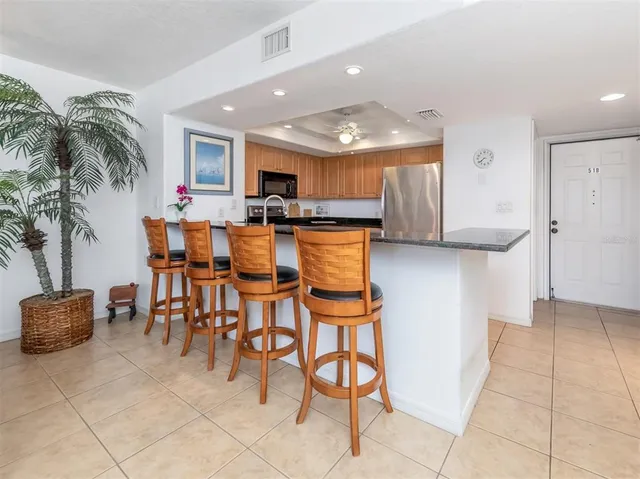 a kitchen with stainless steel appliances kitchen island granite countertop a table and chairs in it