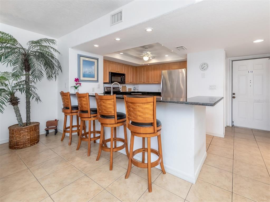601 Shreve Street, Unit 51B Punta Gorda, FL 33950 - Photo 12 of 43 a kitchen with stainless steel appliances kitchen island granite countertop a table and chairs in it