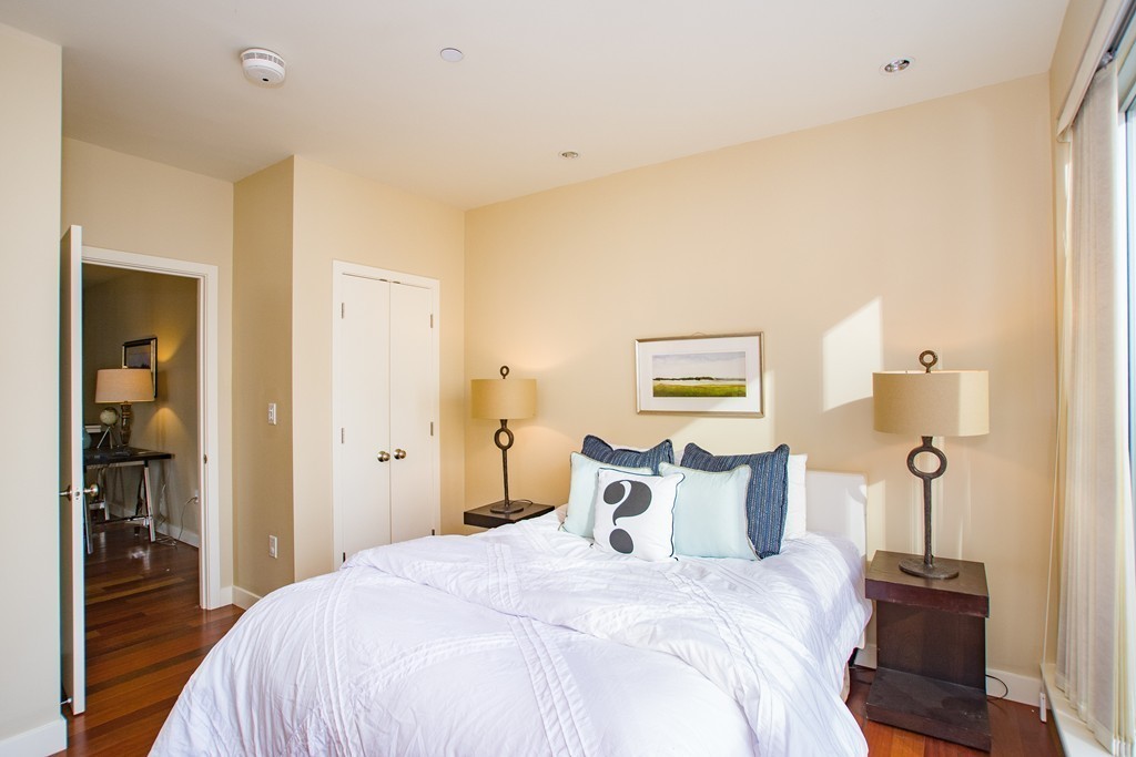 99-105 Broad Street, Unit 8C Boston, MA 02110 - Photo 11 of 28 a bedroom with a bed and a mirror
