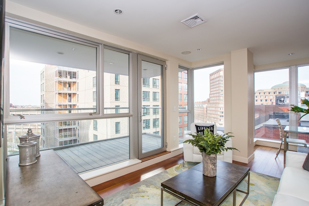 99-105 Broad Street, Unit 8C Boston, MA 02110 - Photo 2 of 28 a living room with furniture and large windows