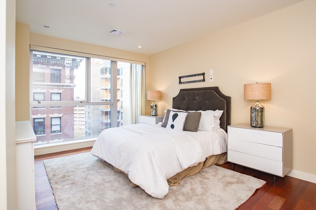 99-105 Broad Street, Unit 8C Boston, MA 02110 - Photo 22 of 28 a bedroom with a large bed and a night stand