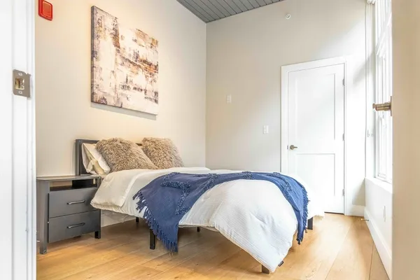 a view of a bedroom with wooden floor and a window