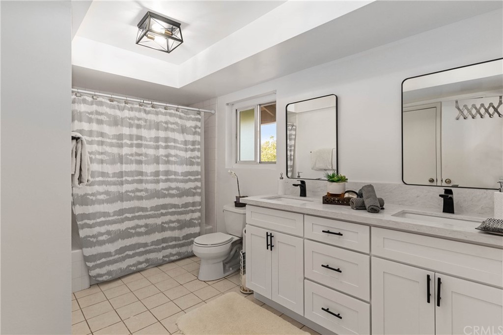 1766 North Mockingbird Place Orange, CA 92867 - Photo 22 of 39 a bathroom with a double vanity sink a toilet a mirror and shower