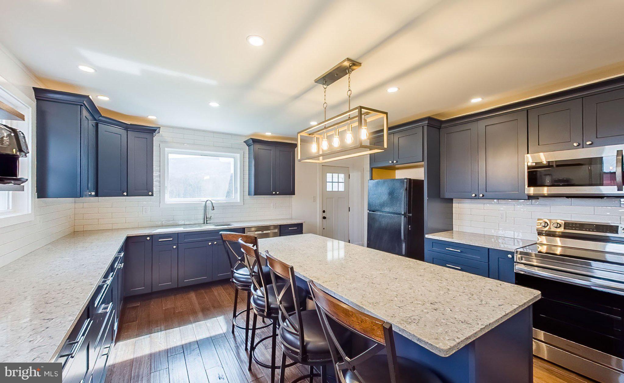 648 Main-Mifflin Road Nescopeck, PA 18635 - Photo 5 of 64 a kitchen with stainless steel appliances granite countertop a stove a refrigerator a sink a dining table and chairs
