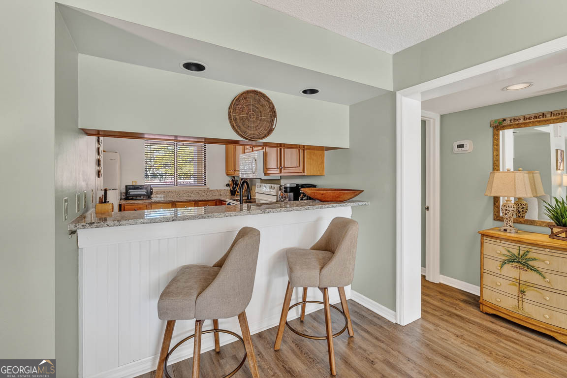 201 Neptune Road, Unit 258 St. Simons, GA 31522 - Photo 11 of 52 a kitchen with stainless steel appliances kitchen island a table chair and a refrigerator
