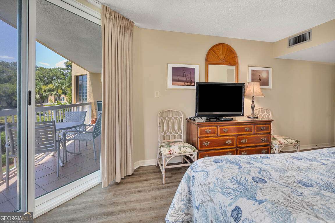 201 Neptune Road, Unit 258 St. Simons, GA 31522 - Photo 13 of 48 a bedroom with a bed and a flat tv screen on dresser