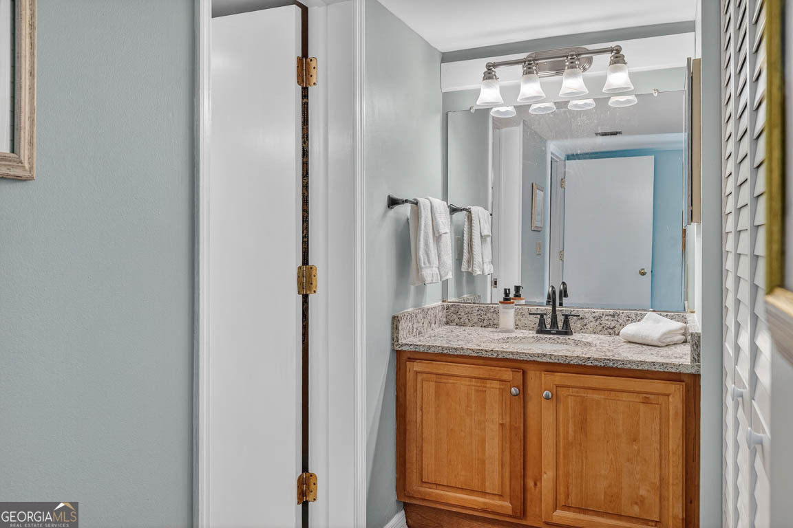 201 Neptune Road, Unit 258 St. Simons, GA 31522 - Photo 16 of 52 a bathroom with a granite countertop sink and a mirror