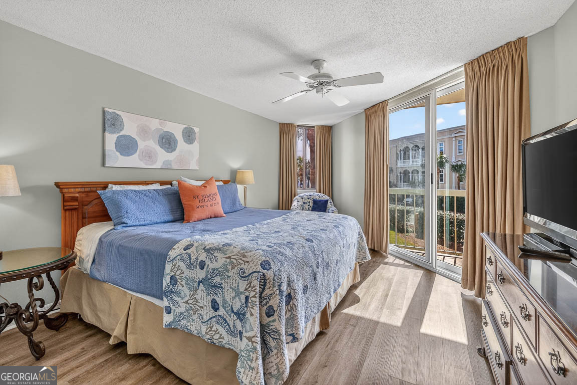 201 Neptune Road, Unit 258 St. Simons, GA 31522 - Photo 19 of 52 a bedroom with a large bed and a flat tv screen on dresser