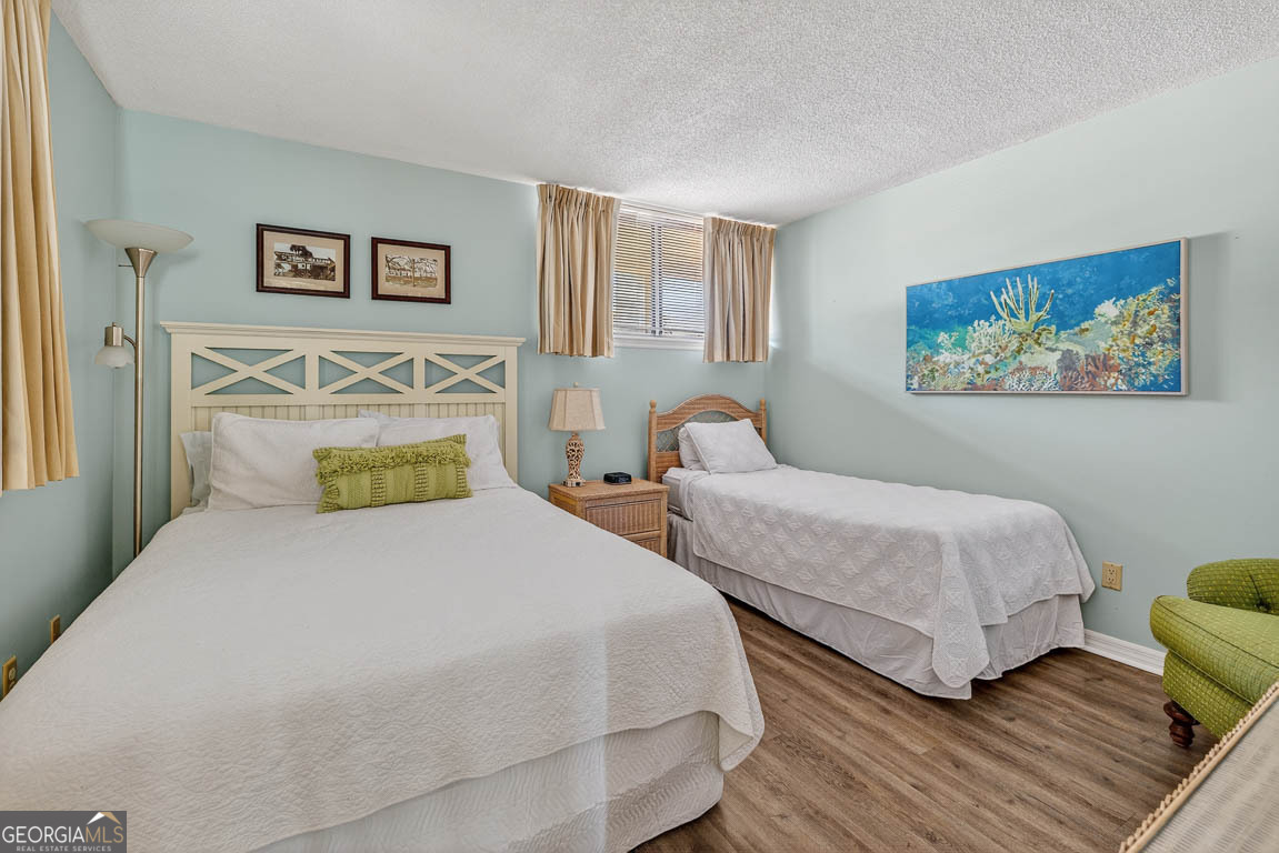 201 Neptune Road, Unit 258 St. Simons, GA 31522 - Photo 22 of 52 a bedroom with two beds and a painting on the wall