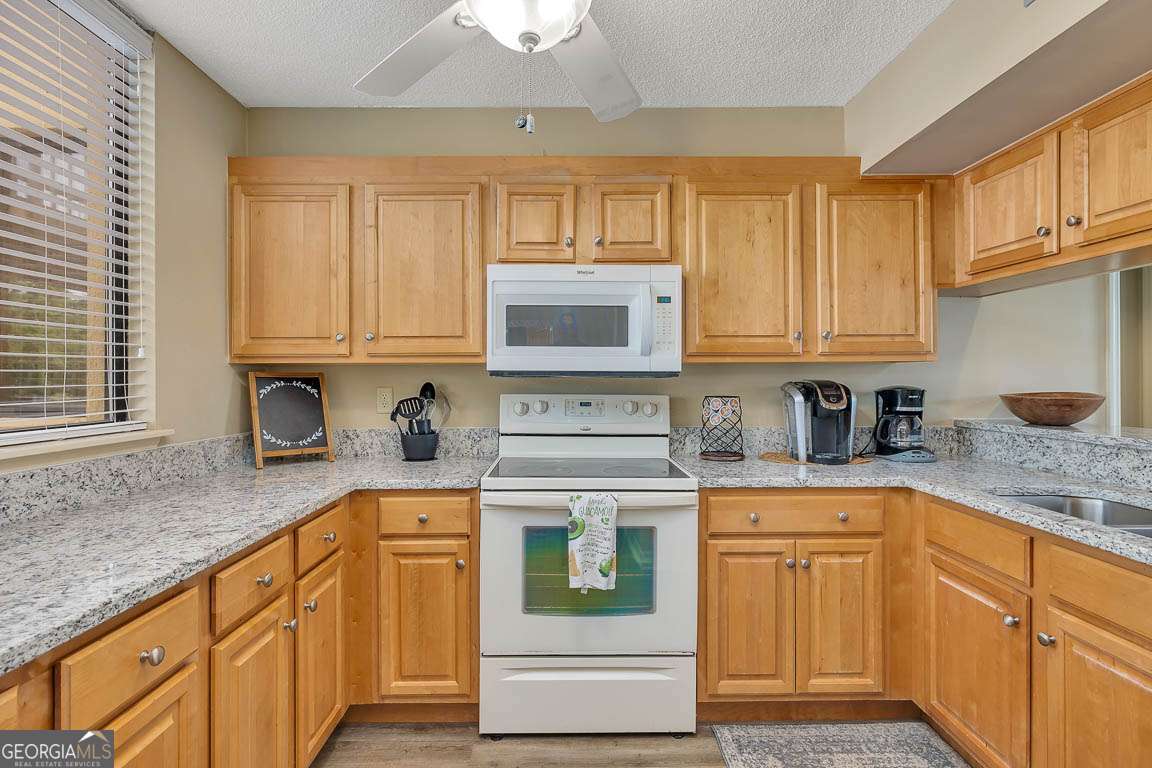 201 Neptune Road, Unit 258 St. Simons, GA 31522 - Photo 23 of 48 a kitchen with stainless steel appliances granite countertop a stove and cabinets