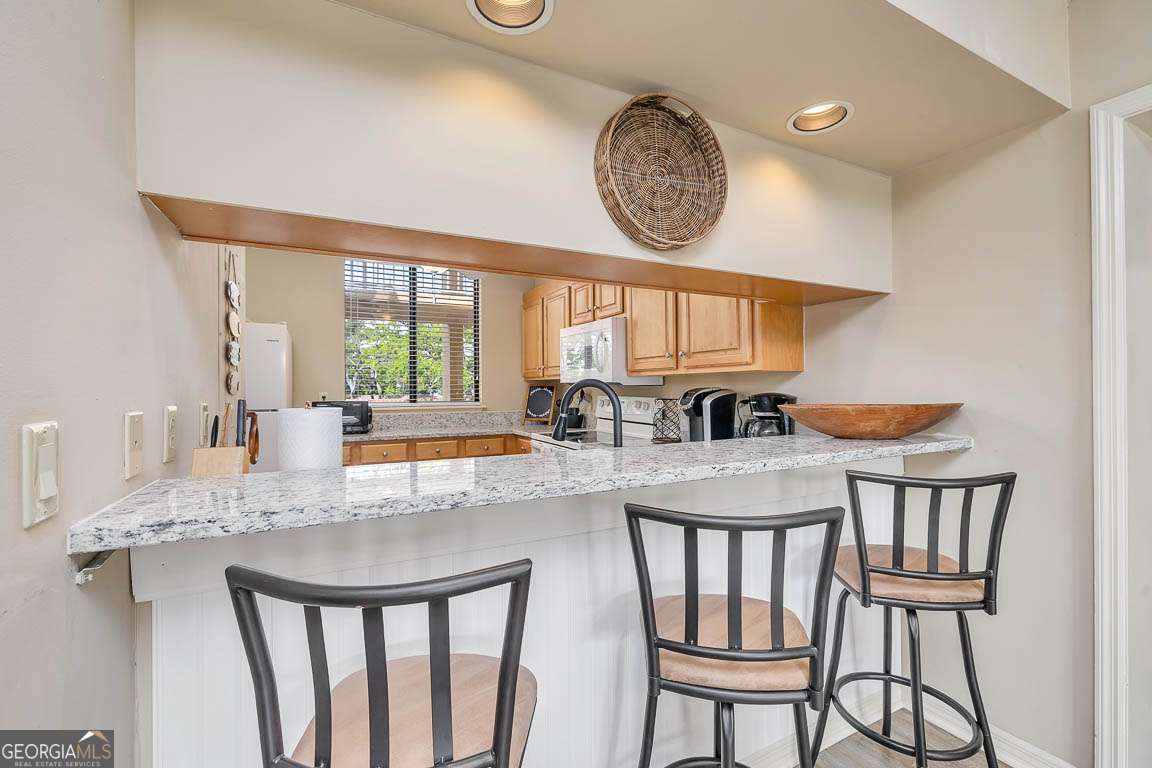 201 Neptune Road, Unit 258 St. Simons, GA 31522 - Photo 26 of 48 a kitchen with a dining table chairs and window