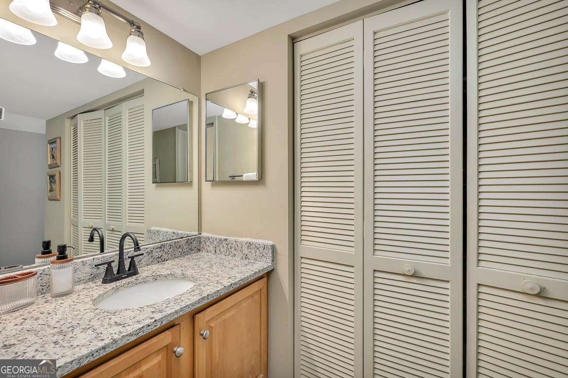 201 Neptune Road, Unit 258 St. Simons, GA 31522 - Photo 27 of 48 a bathroom with a granite countertop sink and a mirror