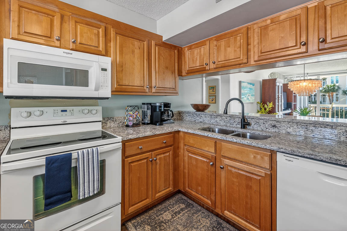 201 Neptune Road, Unit 258 St. Simons, GA 31522 - Photo 3 of 52 a kitchen with stainless steel appliances granite countertop a sink stove and cabinets