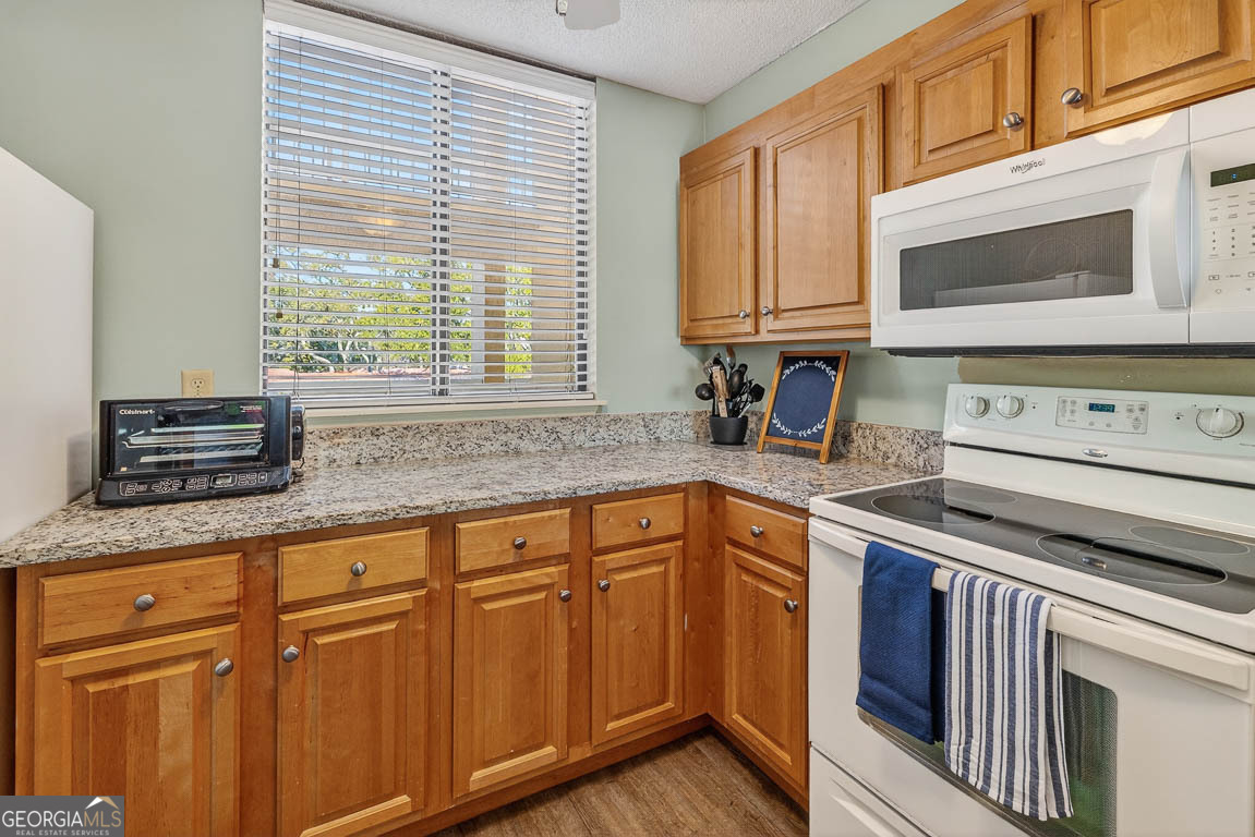 201 Neptune Road, Unit 258 St. Simons, GA 31522 - Photo 4 of 52 a kitchen with granite countertop cabinets stainless steel appliances a sink and window