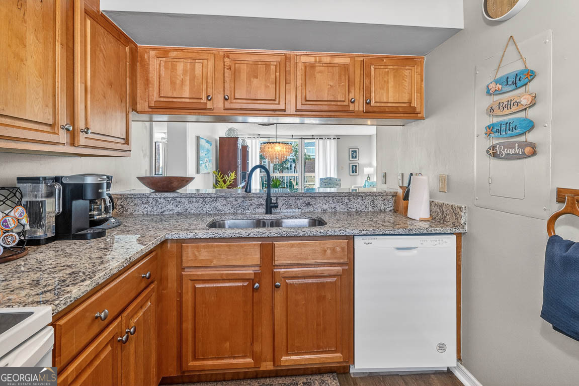 201 Neptune Road, Unit 258 St. Simons, GA 31522 - Photo 5 of 52 a kitchen with granite countertop a sink window and cabinets