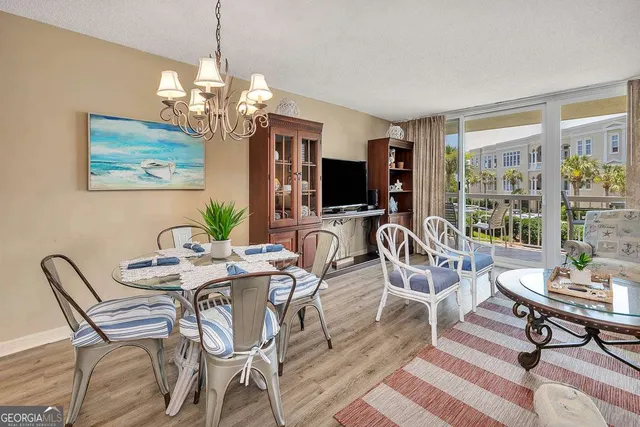 a dining room with furniture a chandelier and wooden floor