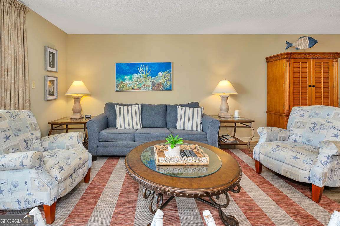 201 Neptune Road, Unit 258 St. Simons, GA 31522 - Photo 7 of 48 a living room with furniture and a wooden floor