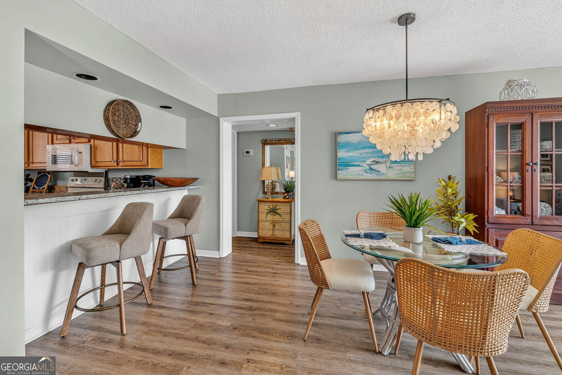 201 Neptune Road, Unit 258 St. Simons, GA 31522 - Photo 8 of 52 a dining room filled chandelier and wooden floor