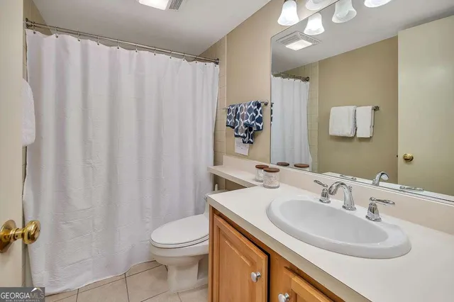 a bathroom with a sink vanity mirror and toilet