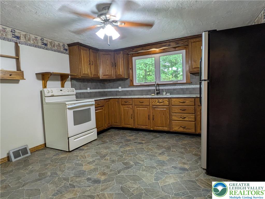 124 Sterling Valley Road Kunkletown, PA 18058 - Photo 13 of 29 a kitchen with stainless steel appliances a stove a sink cabinets and a window