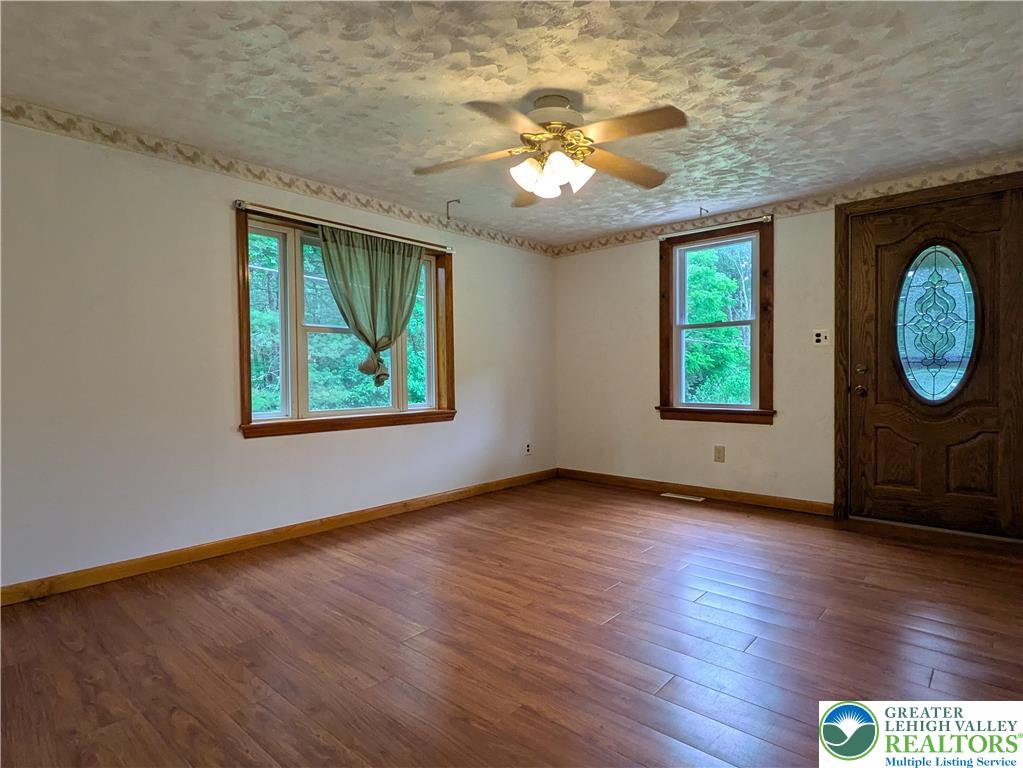 124 Sterling Valley Road Kunkletown, PA 18058 - Photo 17 of 29 an empty room with wooden floor mirror and windows