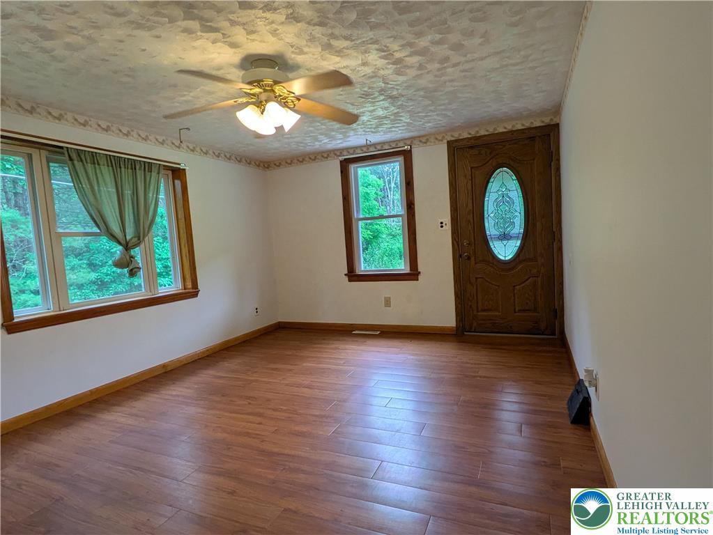 124 Sterling Valley Road Kunkletown, PA 18058 - Photo 18 of 29 an empty room with wooden floor mirror and windows