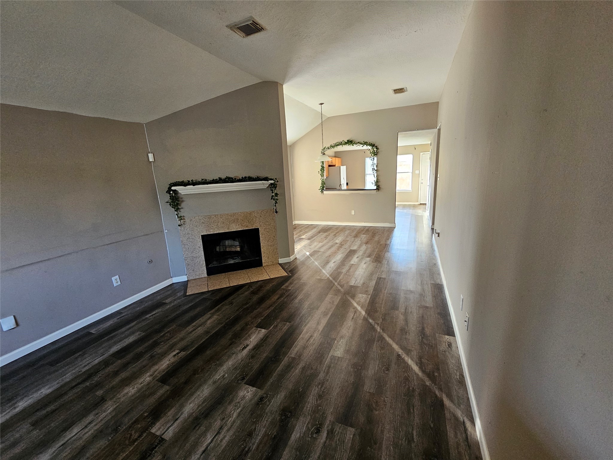 6319 Nullarbor Court Katy, TX 77449 - Photo 6 of 24 a view of an empty room with wooden floor fireplace and a window