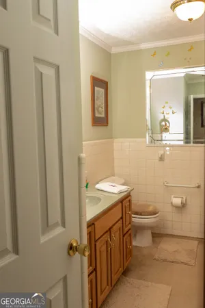 a bathroom with a granite countertop toilet and a sink