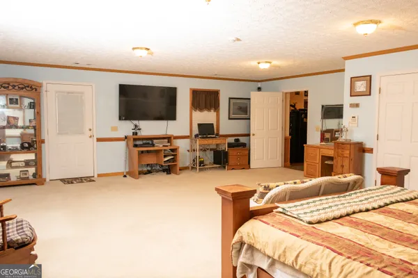 a bedroom with a bed furniture and a flat screen tv