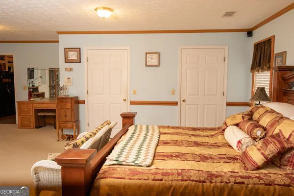 a bedroom with a bed gym equipment and view of living room