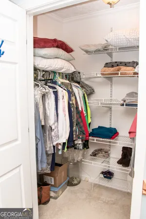 a view of walk in closet with clothes and shoes