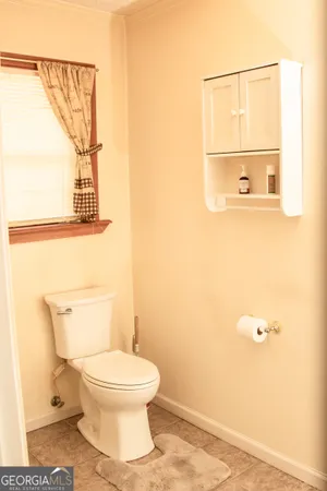 a white toilet sitting next to a bathroom sink and vanity